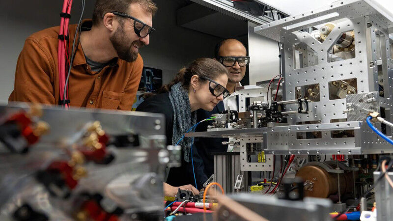 Cystal Senko examines OQD unit with Roger Melko and Rajibul Islam